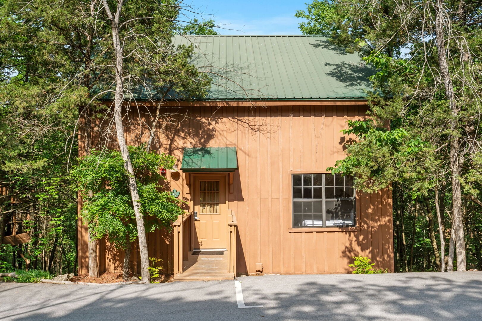 Exterior of a Thousand Hills Vacations fireplace cabin surrounded by trees near Branson, Missouri